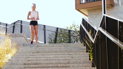 Fitness, Sport mit gesundem Lebensstil - Junge Frau läuft die Treppe hinunter