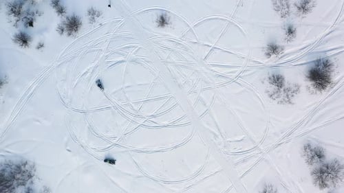 Snowmobiles Drawing Circles on a Snowy Field
