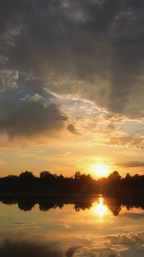 Golden Sunset Reflection on Water with Dramatic Clouds