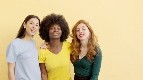 Tres mujeres multiculturales sonriendo a la cámara al aire libre