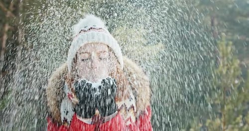 Woman Blowing Snow in Winter Wonderland