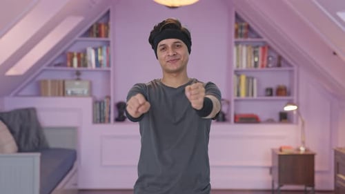Glücklicher indischer Mann macht Handgelenkrotationsübung