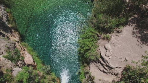 Aerial shot of waterfall and crystal clear water in the river. Colourful water