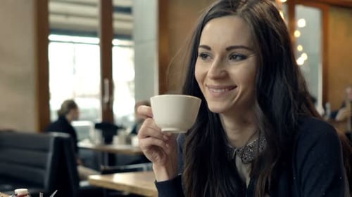 Young, Elegant Woman Relaxing and Drinking Coffee in Cafe 30s