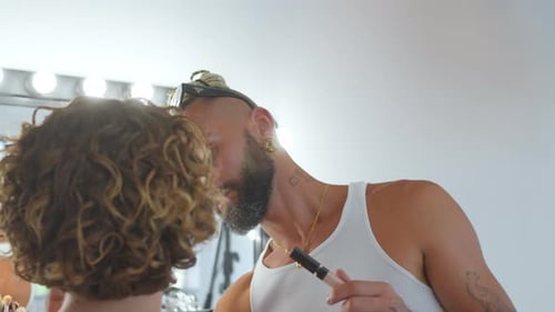Makeup Artist Applies Makeup on a Woman Indoors