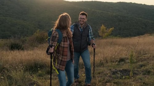 Smiling Couple Hiking in Golden Mountain Field