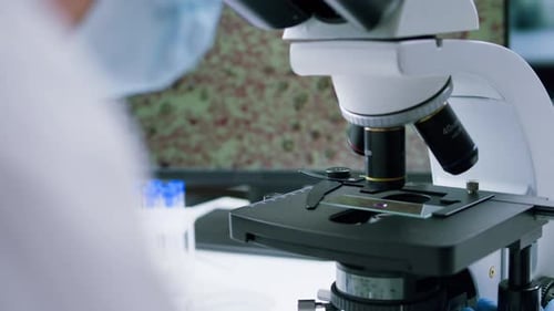 Medical Professional Using Microscope in a Laboratory Setting