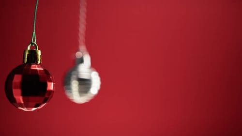 Swinging Christmas Ornaments on Red Background