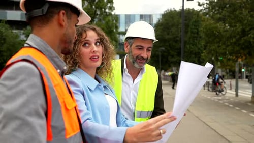 Professional Architects and Engineers Reviewing Building Blueprints