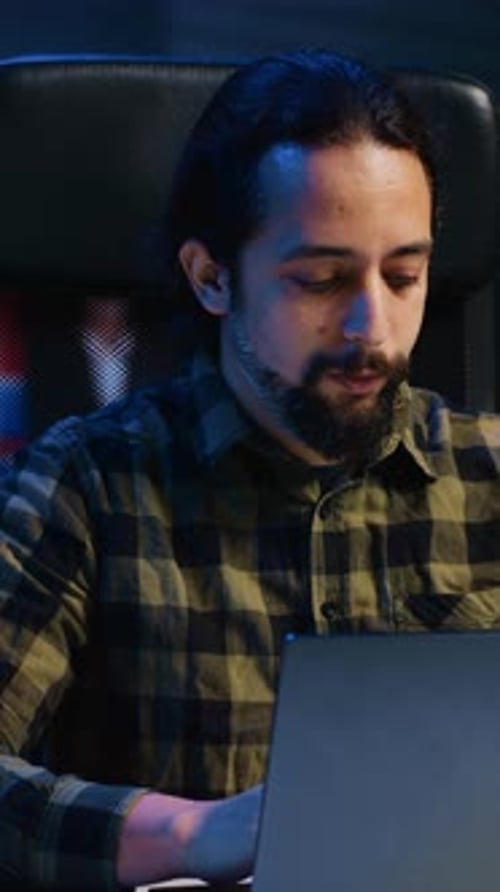 Young Adult Works on Laptop at Night