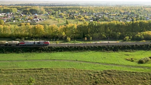 Freight Train Passing Through Countryside In the Afternoon in Autumn Day Aerial View