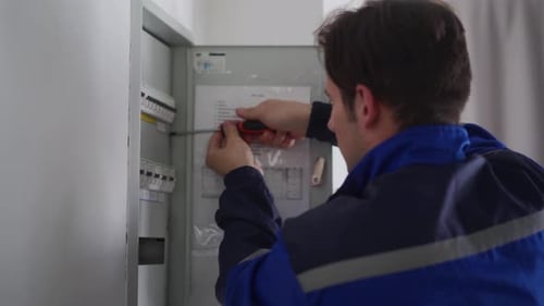 Electrician Working on Electrical Panel Indoors