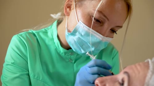 Nahaufnahme Kosmetikerin Hände in Handschuhen macht Gesichtsalterung Injektion in weibliche Haut Frau bekommt Schönheit