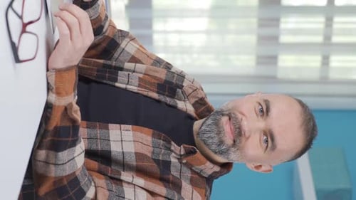 Man Smiling Using Tablet, Gives Thumbs Up