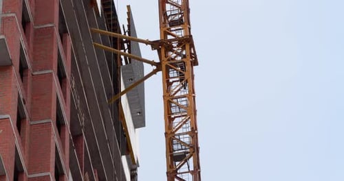 Un grutier quitte son lieu de travail à l'extérieur. Bâtiment inachevé