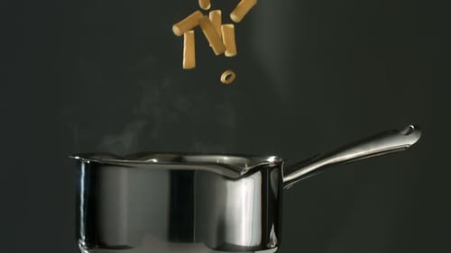 Pasta falling into a pot of boiling water