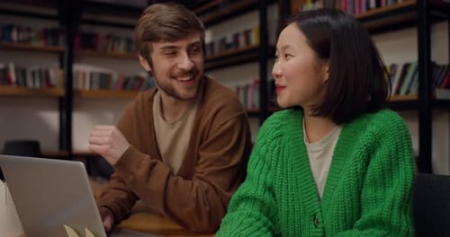 A Happy Asian Brunette Girl and Her Boyfriend Come to a Joyful Solution to a Problem While Studying
