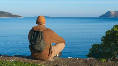 Man Raising Arms By the Sea Embracing Freedom and Serenity