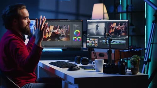 Video Editor Working at Desk in Blue-lit Room
