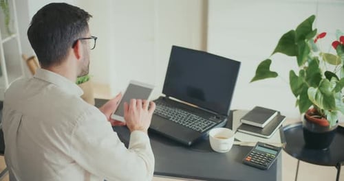 Contemplative Businessman Working On Digita Tablet In Office