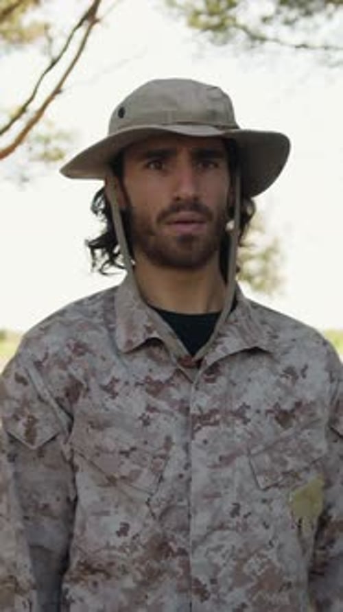 Man in Camouflage Uniform Saluting Outdoors