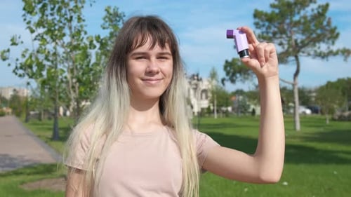 Teen with Inhaler Against Garden
