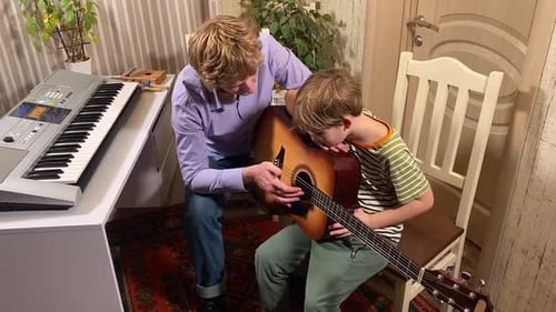 Man Teaching Child How to Play Guitar
