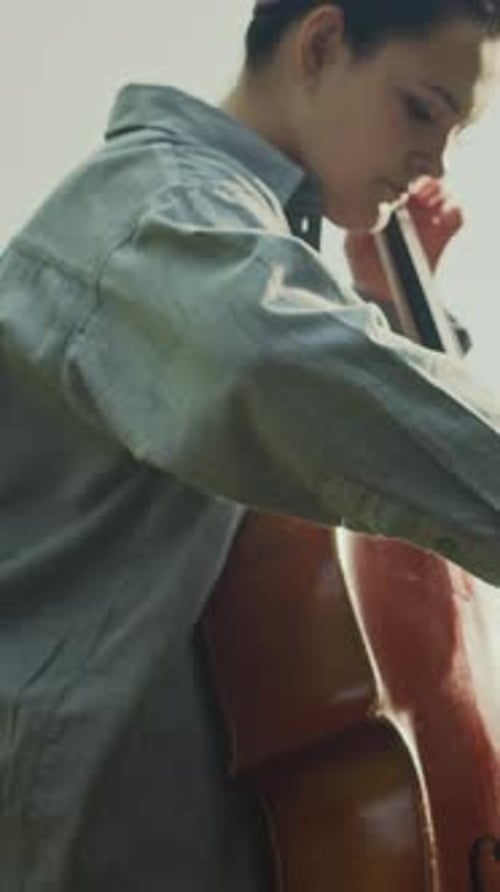 Woman Playing Cello Outdoors on a Sunny Day