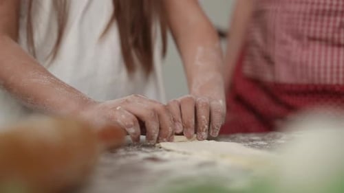 Slow Motion Closeup Cooking with Mom The Girl Twists a Strip of Dough Into a Roll with Both Hands