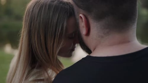 Loving Couple Embrace Outdoors with Heads Together