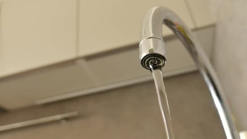 Blick aus einem niedrigen Winkel auf Wasser, das aus einem Wasserhahn fließt