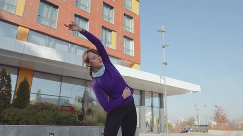 Young Woman Stretching Outdoors Preparing for a Fitness Workout in the City