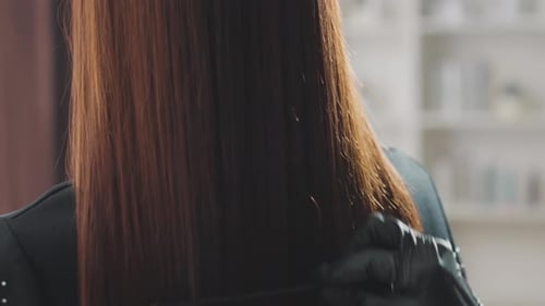 Woman with Auburn Hair Getting Combed in Salon