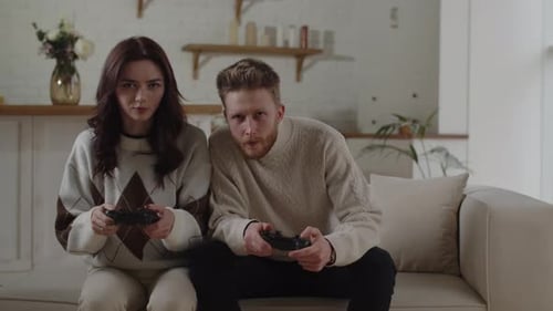 Front View of a Couple Playing Video Games at Home Bearded Man with Controller Lost the Game to His