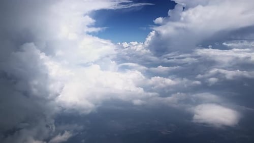 Aerial View of Majestic Cloudscape From an Airplane Window with Sunlight Piercing Through
