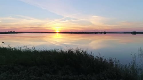 Aerial Over the Lake at Sunset Soft Sunset Skies Reflections on Calm Water Surface Stunning Summer