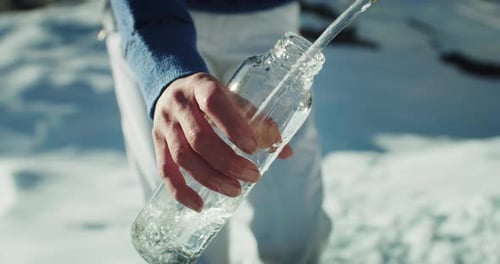 Cinematic Close Up shot of Female Hands Filling a Glass Bottle with Fresh Pure Cold Water fr