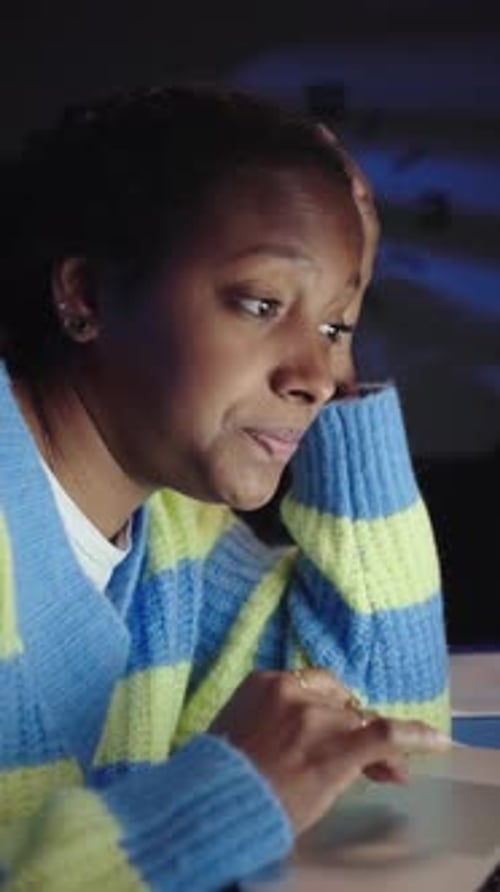 Young Black American Female Student Bored and Tired Writing and Using Laptop Sitting at Desk Home