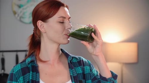 Portrait of Cute Woman Holding a Glass of Green Smoothie in Her Hands From Fresh Vegetables and