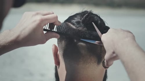 Man Getting Haircut by Barber with Scissors and Comb