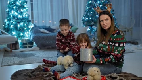 Mother and Children Opening Christmas Present Together