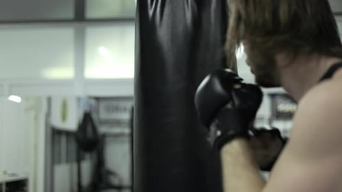 Black Punching Bag Getting Smashed Under Impact of Caucasian Person Hits