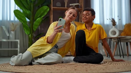 Young Woman and Boy Using Smartphone Together Indoors