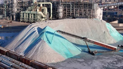 Drone video of Conveyor dumping blue salt near industrial complex at Detroit salt factory
