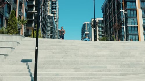 Athletic Man Runs Down Urban Concrete Steps