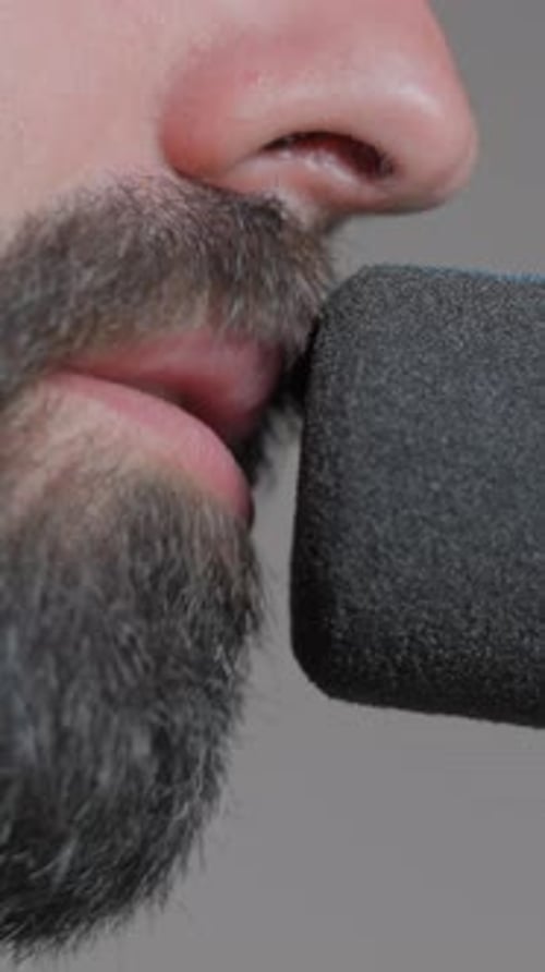 Man Talking Into a Microphone Close Up