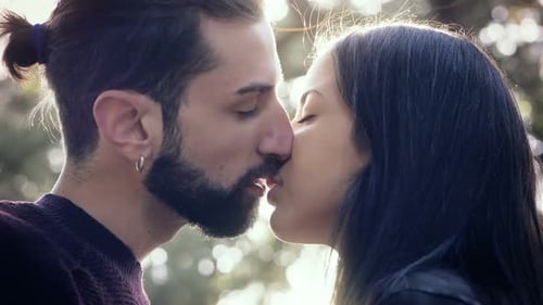 Young Beautiful lovers kissing in the park.Love,romance,nature