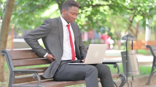 Young Man Working on Laptop Outdoors