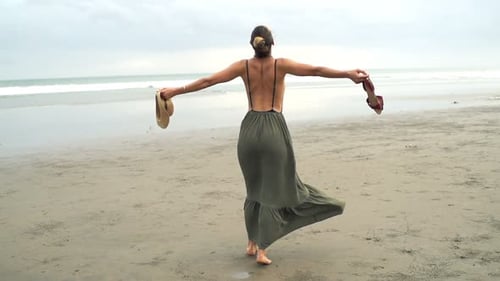 Frau mit weit geöffneten Armen genießt den Tag am Strand, Superzeitlupe 240fps