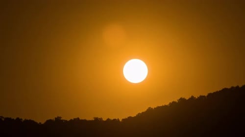 Timelapse of dramatic sunset with orange sky in a sunny day.